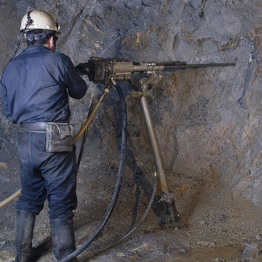 Pneumatic rock drill supported by an FT160-series air leg at an underground rock face